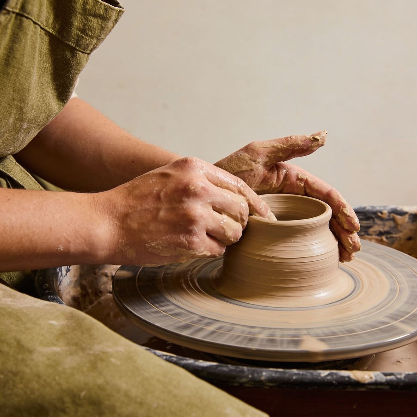 Mani che modellano l'argilla su un tornio da ceramica